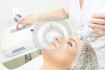 Microcurrent facial dermatology procedure. Model. Aesthetic radiofrequency treatment. Micro current cosmetology massage Stock Photo