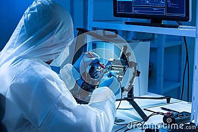 Microelectronics engineer works in a modern scientific laboratory on computing systems and microprocessors. Electronic Stock Photo