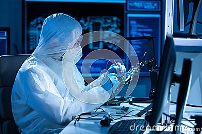 Microelectronics engineer works in a modern scientific laboratory on computing systems and microprocessors. Electronic Stock Photo