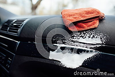 Microfiber cloth and foam on a car cockpit. Auto clean concept Stock Photo