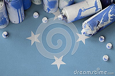 Micronesia flag and few used aerosol spray cans for graffiti painting. Street art culture concept Stock Photo