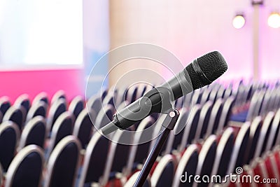 Microphone on the background of rows of chairs in the hall Stock Photo