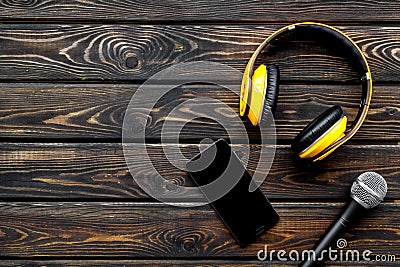 Microphone, headphones, mobile for blogger, journalist or musician work on wooden background top view mockup Stock Photo