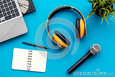 Microphone, headphones, notebook and laptop for blogger, journalist or musician work on blue background top view mock-up Stock Photo