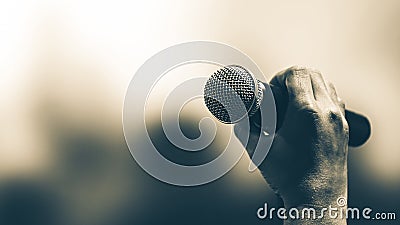 Microphone Public speaking background, Close-up hand holding microphone on stand for speaker speech presentation stage performance Stock Photo