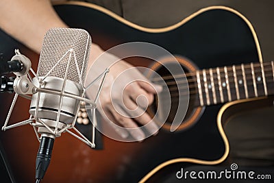 Microphone recording an acoustic guitar played by hand Stock Photo