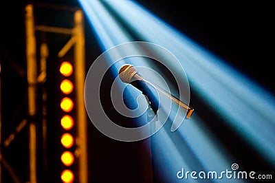 A microphone on a stand of a classic look in the light of the spotlights shot on a dark background Stock Photo