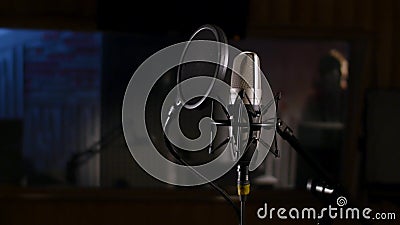 Microphone on a stand located in a music studio recording booth under low key light Stock Photo