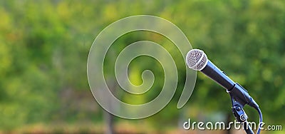 Microphone standing for speaker on the outdoor natural setting for music, concert and environmental awareness talk with copy space Stock Photo