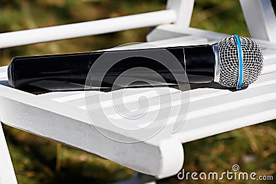 Microphone on white wooden chair Stock Photo