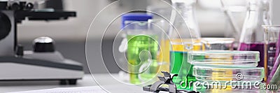 Microscope multicolored liquid in test tubes and papers on table in laboratory Stock Photo