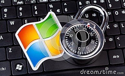 Microsoft Windows logo and a coded padlock, code lock symbol laying on a laptop keyboard. System safety and data security, hacking Editorial Stock Photo