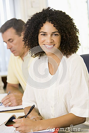 Mid adult woman studying with other adult students Stock Photo