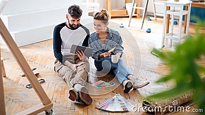 Mid adults couple planning with tablet indoors at home, relocation and diy concept. Stock Photo