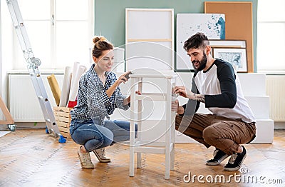 Mid adults couple renovating furniture indoors at home, relocation and diy concept. Stock Photo