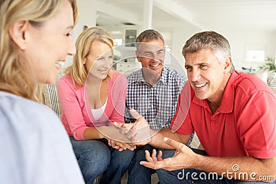 Mid age couples chatting at home Stock Photo