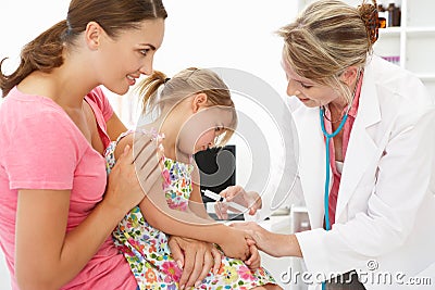 Mid age female doctor injecting young child Stock Photo