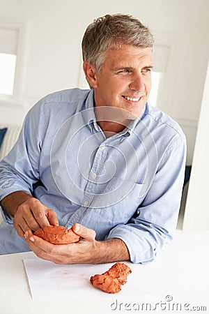 Mid age man clay modelling Stock Photo