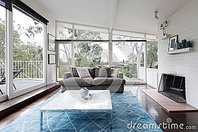 Mid century modern living room with huge windows to view the treetops Stock Photo