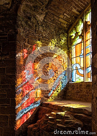 Sunlight streaming through a stained glass window, Goodrich Castle, Herefordshire. Stock Photo