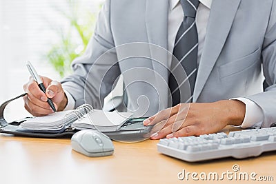 Mid section of a businessman writing in diary Stock Photo