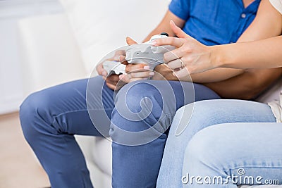Mid section of couple playing video game Stock Photo