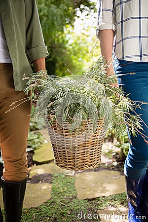 Mid-section of couple walking with flower basket Stock Photo