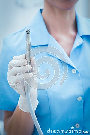 Mid section of dentist holding dental drill Stock Photo