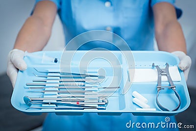 Mid section of dentist holding tray of tools Stock Photo