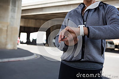 Female jogger using smartwatch on a sunny day Stock Photo