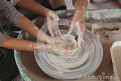 Mid section of female potter assisting girls Stock Photo