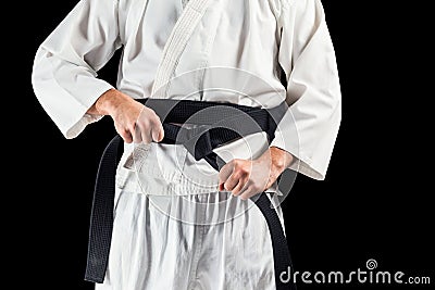 Mid section of fighter tightening karate belt Stock Photo