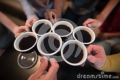 Mid section of friends toasting coffee Stock Photo
