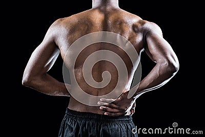 Mid section of muscular athlete suffering through back pain Stock Photo