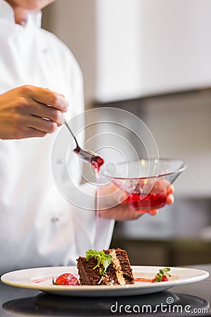 Mid section of a pastry chef decorating dessert in kitchen Stock Photo