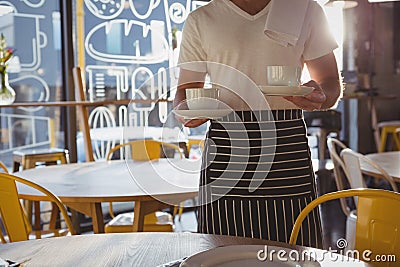 Mid section of waiter holding coffee cups Stock Photo