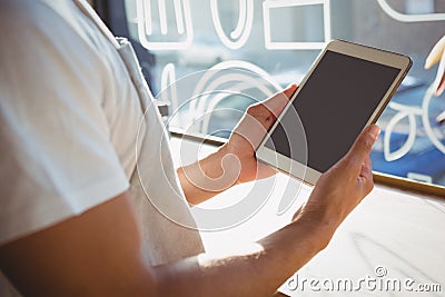 Mid section of waiter holding tablet in cafe Stock Photo