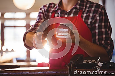 Mid section of waiter showing credit card machine Stock Photo