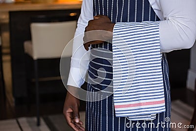 Mid section of waiter standing with towel Stock Photo