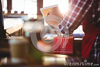 Mid section of waiter using digital tablet Stock Photo