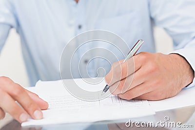 Mid section of a young man writing documents Stock Photo