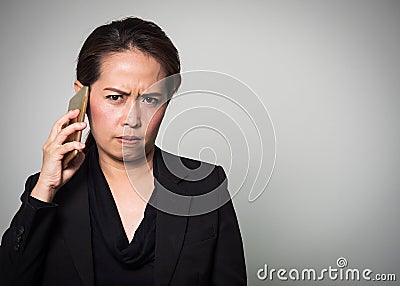 Middle adult Asian woman holding smart phone in angry and boring Stock Photo