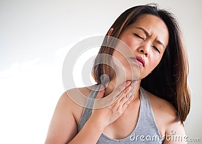 Middle adult Asian woman sore throat and using hand touching on Stock Photo