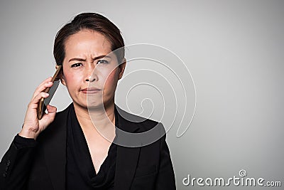 Middle adult Asian woman used smart phone. Action boring and take away from ear. Stock Photo