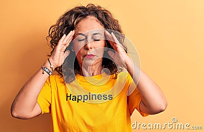 Middle age beautiful woman wearing t-shirt with happiness word over yellow background with hand on head, headache because stress Stock Photo