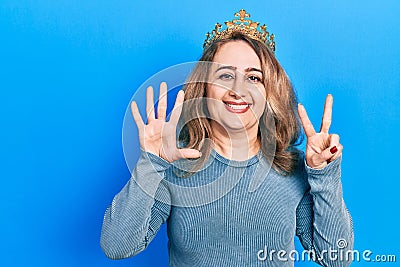 Middle age caucasian woman wearing queen crown showing and pointing up with fingers number seven while smiling confident and happy Stock Photo