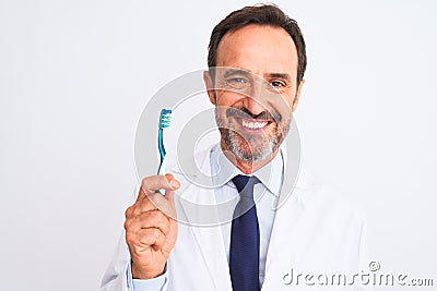 Middle age dentist man holding toothbrush standing over isolated white background with a happy face standing and smiling with a Stock Photo