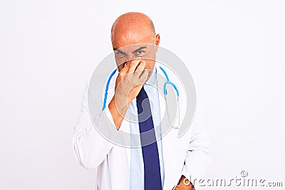 Middle age doctor man wearing stethoscope and tie standing over isolated white background smelling something stinky and Stock Photo
