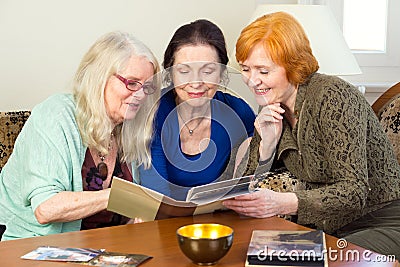 Middle Age Female Friends Looking at Photo Album Stock Photo