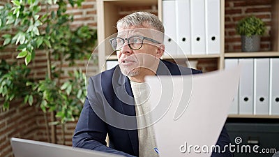 Middle age grey-haired man business worker stressed reading document at office Stock Photo